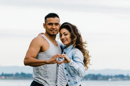 Engaged couple is holding hands in a heart shape