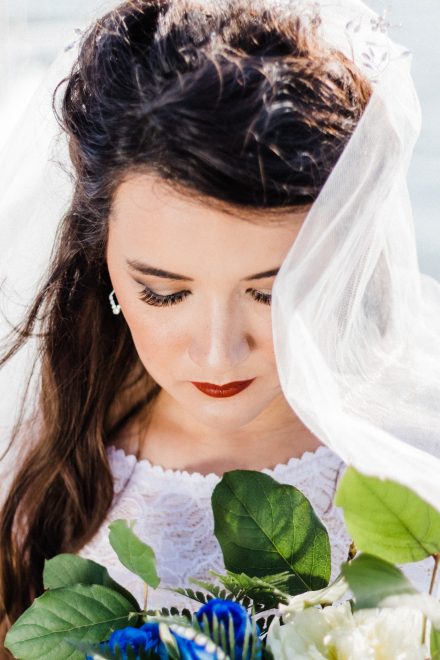 Portrait of a bride looking at her bouquet with blue roses